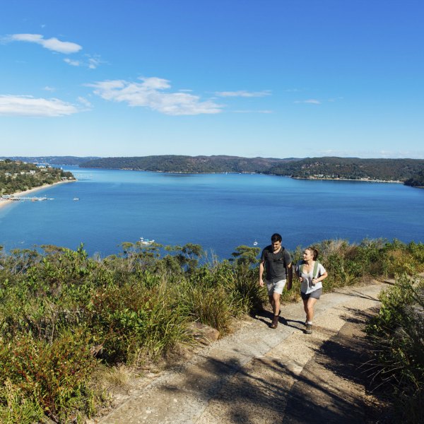 a group of people walking on a path near a body of water