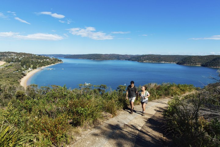 a group of people walking on a path near a body of water