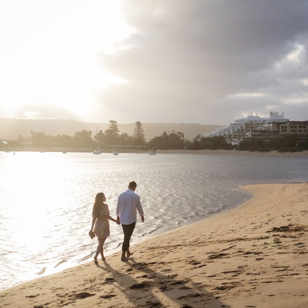 a man standing on a beach near a body of water
